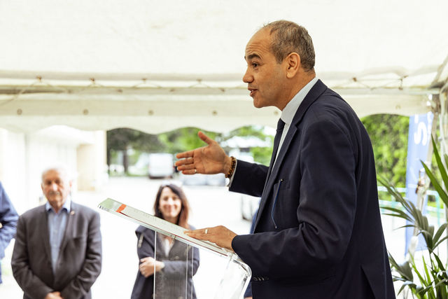 Homme en costume s'exprimant à un pupitre lors d'un événement