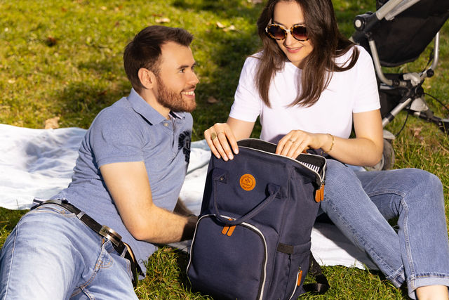 Couple assis sur une couverture avec sac à dos bleu marine