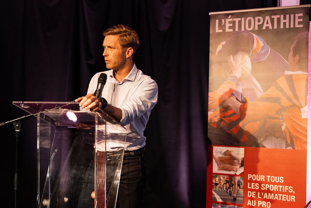 Homme parlant à un pupitre pendant une conférence sur l’étiopathie