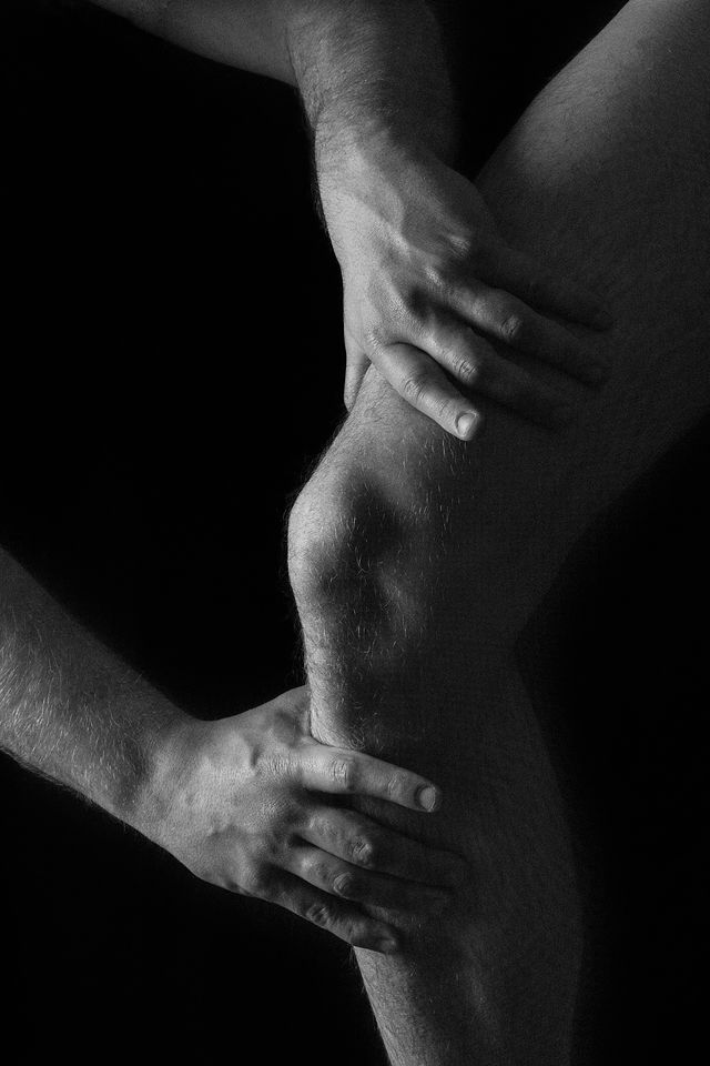 Photo artistique de mains posées sur un genou en noir et blanc