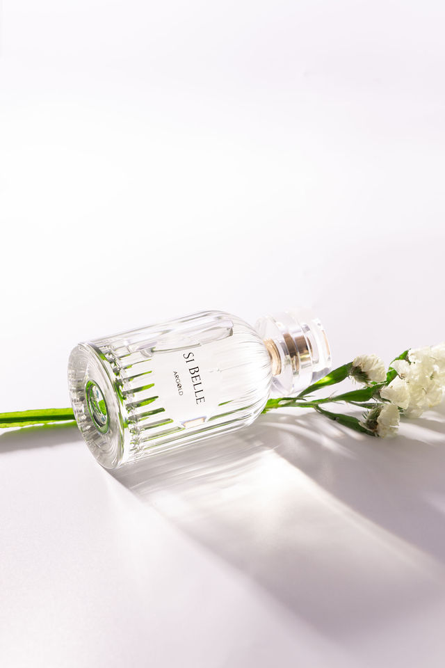 Flacon de parfum Si Belle allongé avec fleurs blanches