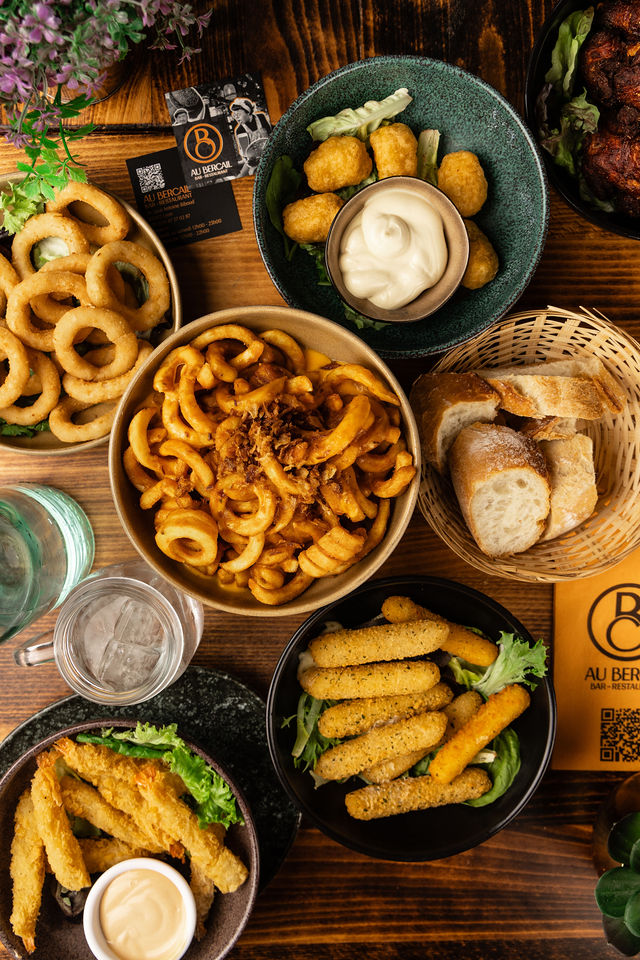 Assortiment de street food et fritures servi au restaurant Au Bercail, ambiance chaleureuse