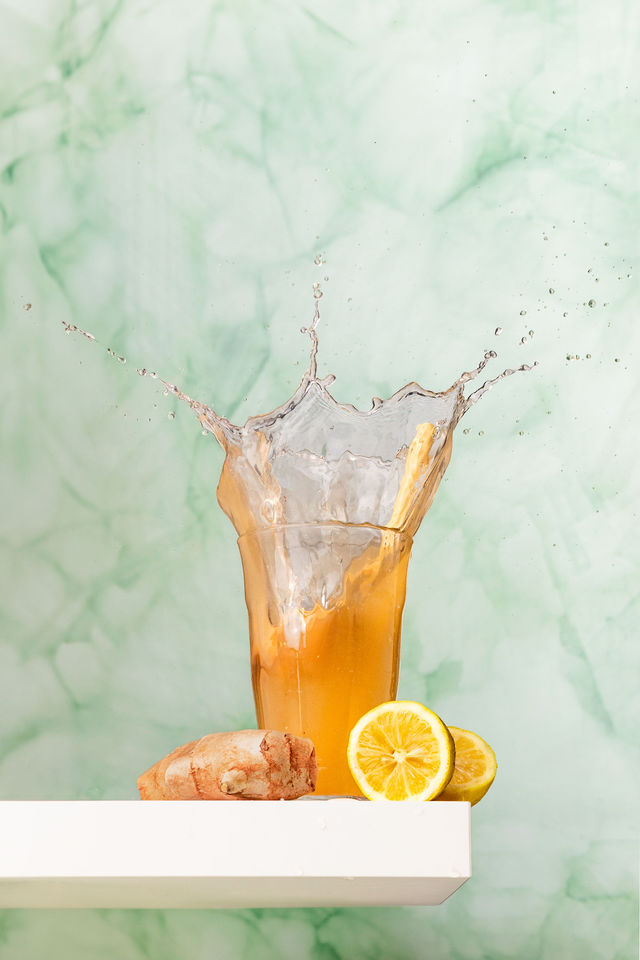 Verre de boisson citron-gingembre avec éclaboussure, photo culinaire en studio