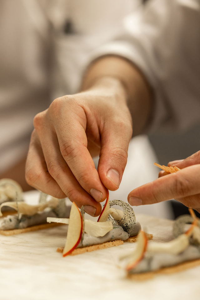 Dressage minutieux avec tranche de pomme sur amuse-bouche raffiné, mains en gros plan