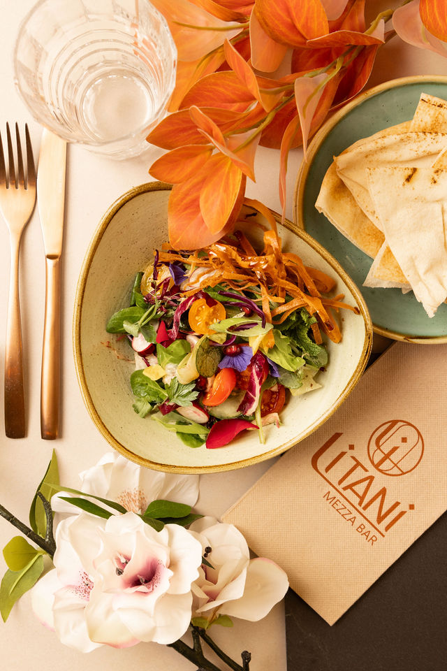 Salade colorée servie au restaurant Litani avec fleurs comestibles et pain libanais