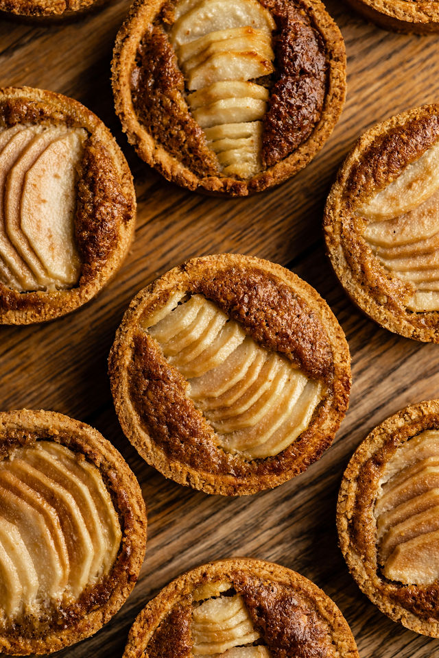 Tartelette individuelle à la poire et à la frangipane sur fond bois foncé
