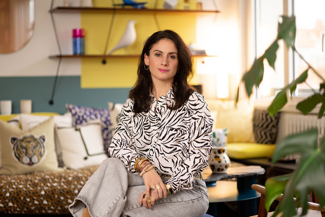 Portrait femme assise dans un salon coloré et design