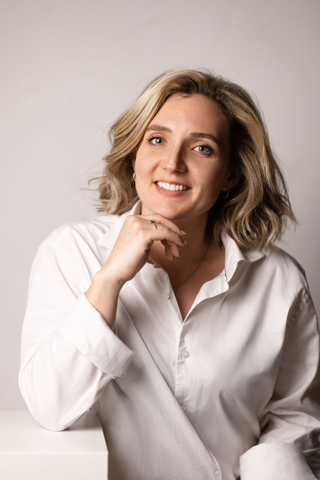 Portrait femme blonde en chemise blanche sur fond neutre