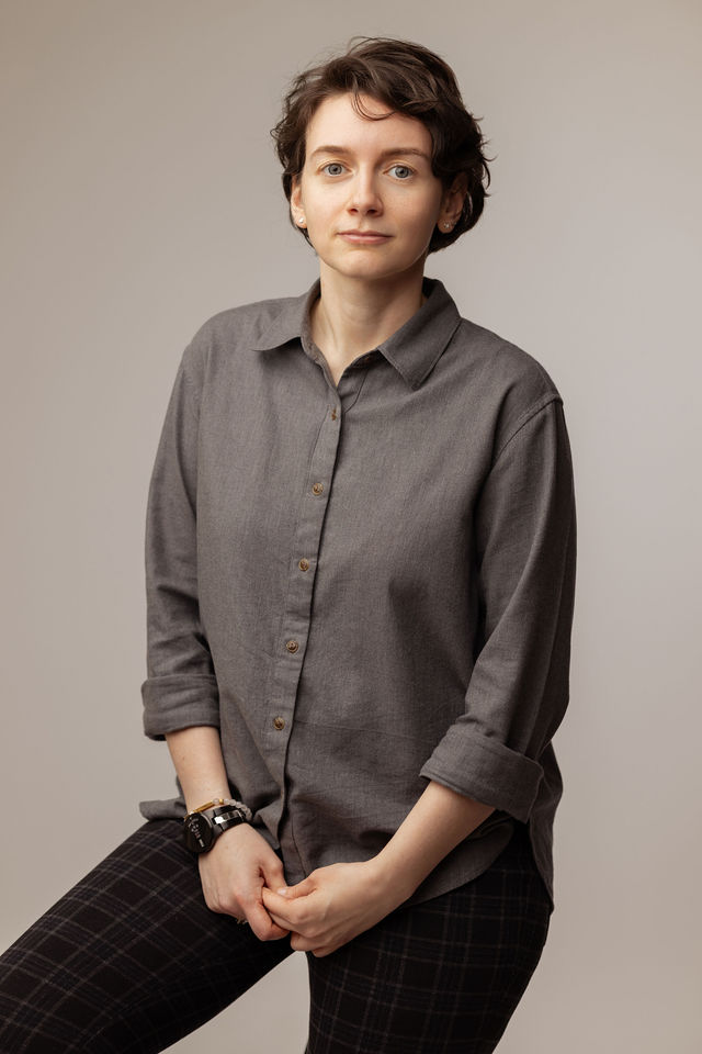 Portrait d’une femme en chemise grise avec expression sérieuse