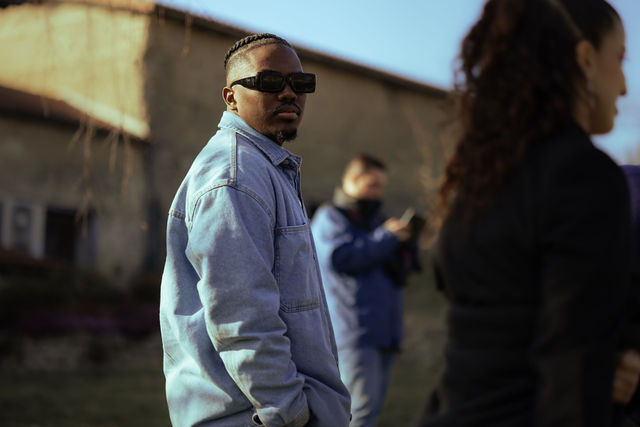 Homme en veste en jean et lunettes de soleil, extérieur ensoleillé