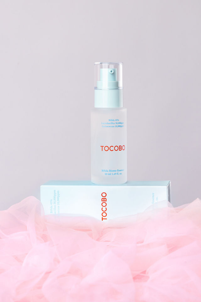 Flacon en verre givré de l’essence Tocobo posé sur sa boîte